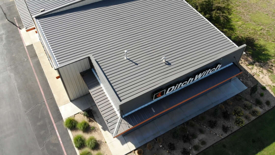 Ditch witch gray roof from drone angle with signage and landscaping